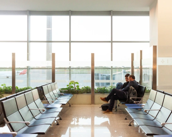 dos hombres sentados en la sala de espera de un aeropuerto