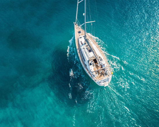 yate a vela blanco navegando sobre agua turquesa.